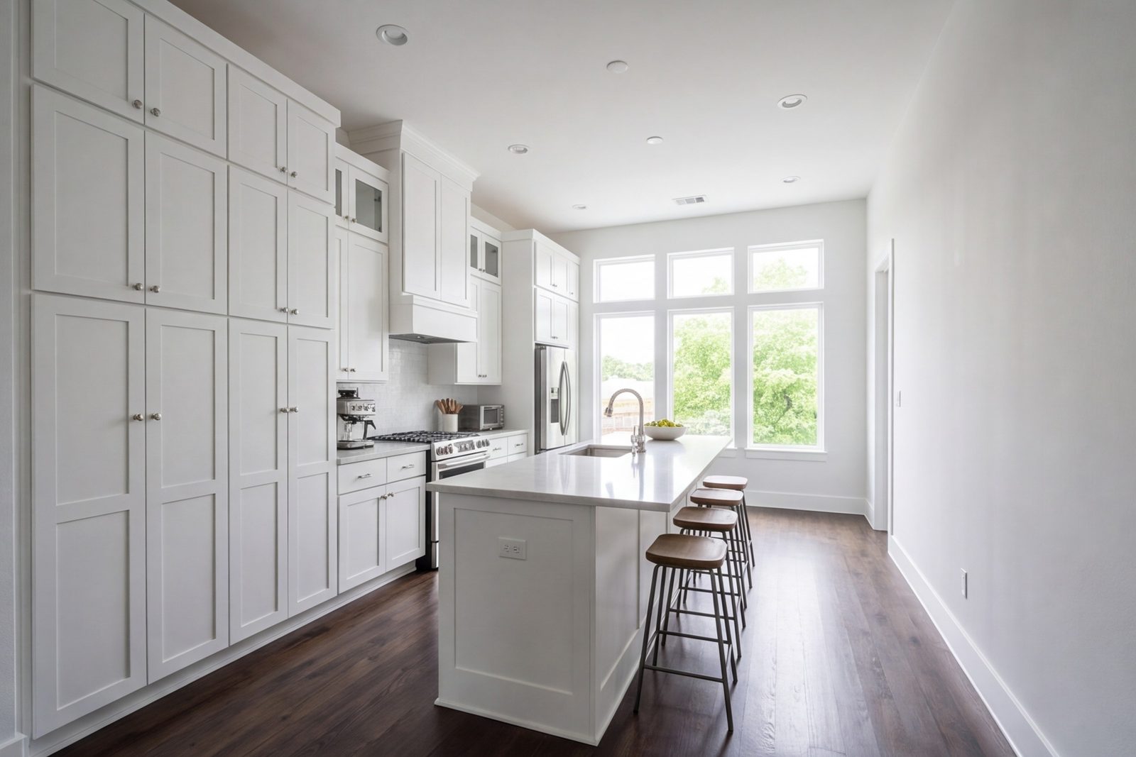 Narrow Uptown townhome kitchen with a long island and tall white cabinets